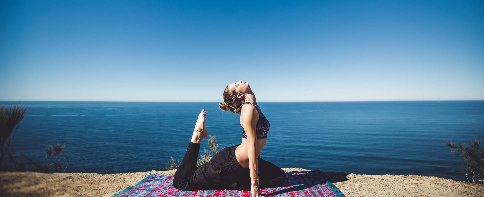 Photo of woman doing yoga by the ocean by Matthew Kane